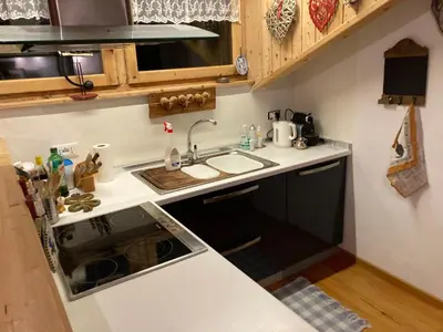 a small kitchen with a sink and a stove at Appartamento Cortina d'Ampezzo Lovely Hearts in Cortina dʼAmpezzo
