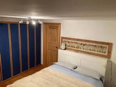 a bedroom with a bed and a blue wall at Appartamento Cortina d'Ampezzo Lovely Hearts in Cortina dʼAmpezzo