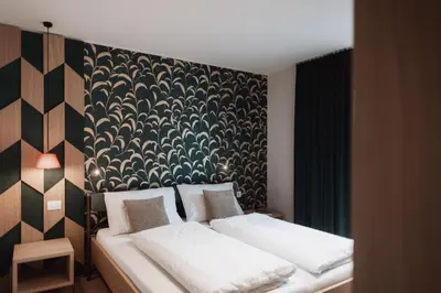 a bedroom with two beds and a black and white wall at Der Mittermoar in Bressanone