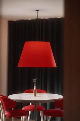 a red lamp over a white table with red chairs at Der Mittermoar in Bressanone