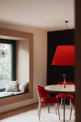 a dining room with a red lamp and a table and chairs at Der Mittermoar in Bressanone