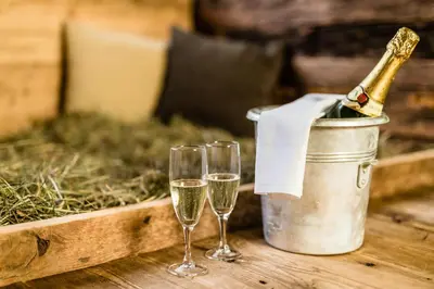 two glasses of champagne on a table with a bucket at Gasthof Eggwirt in Ultimo