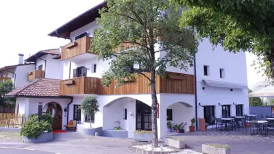 a white building with a tree in front of it at Zur Mühle in Ora/Auer