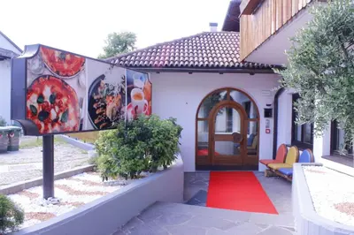 a house with a red carpet in front of a door at Zur Mühle in Ora/Auer