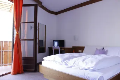 a bedroom with a bed and a sliding glass door at Zur Mühle in Ora/Auer