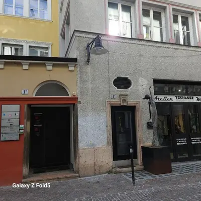 a building on a street with a statue in front of it at Ka.La Apartment in Bolzano