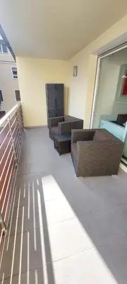 a balcony with two chairs and tables on a building at ROCCO's APARTMENT - in centro a Merano in Merano