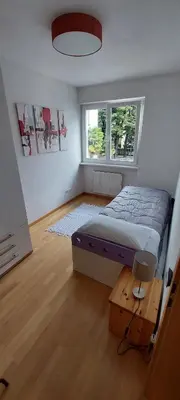 a bedroom with a bed and a table and a window at ROCCO's APARTMENT - in centro a Merano in Merano