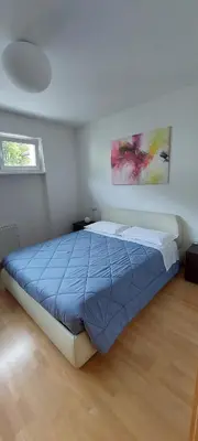a bedroom with a bed with a blue comforter at ROCCO's APARTMENT - in centro a Merano in Merano