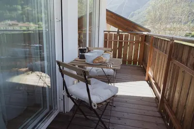 a porch with a table and a chair on a balcony at 164 apt. in Val di Vizze
