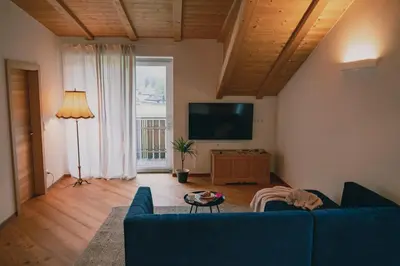a living room with a blue couch and a television at 164 apt. in Val di Vizze
