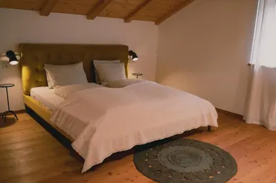 a bedroom with a large bed with white sheets and a rug at 164 apt. in Val di Vizze