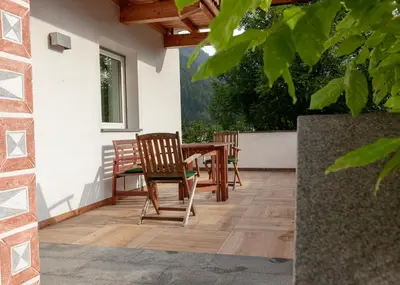 a patio with two chairs and a wooden table at 164 apt. in Val di Vizze