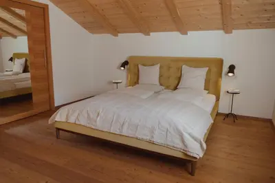 a bedroom with a large bed with white sheets and pillows at 164 apt. in Val di Vizze