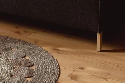 a rug on a wooden floor next to a chair at 164 apt. in Val di Vizze