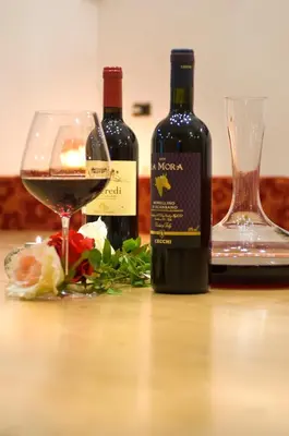 two bottles of wine and a glass on a table at Hotel Daniela in Merano