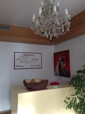 a chandelier in a room with a sign on the wall at Hotel Daniela in Merano