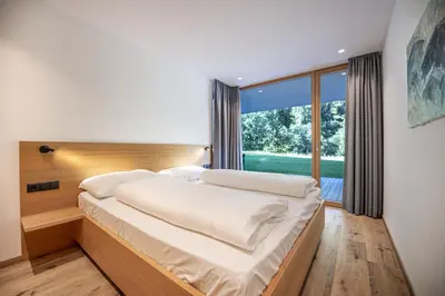 a bedroom with a large bed and a large window at Greva Apartments 1 in Santa Cristina in Val Gardena