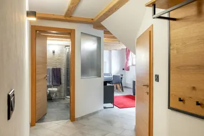 a hallway with a door leading to a bathroom at Apart Dolomites in Castello di Fiemme