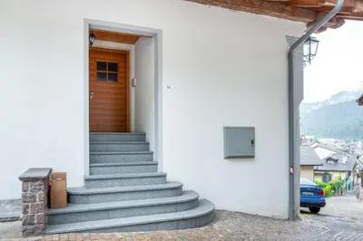 a stairway leading up to a building with a door at Apart Dolomites in Castello di Fiemme
