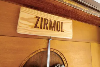 a zarma sign on a building with a door at Dolomitihouse ZIRMOL in Fiera di Primiero