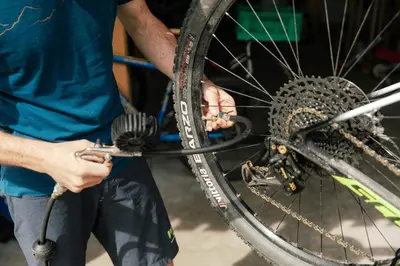 a man is washing a bike tire with a brush at Dolomitihouse ZIRMOL in Fiera di Primiero