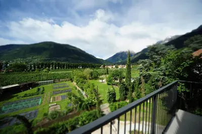 a balcony with a view of a garden and mountains at Villa Sasso in Merano