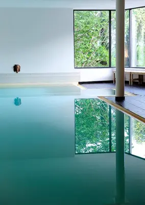 a pool of water in a room with large windows at Villa Sasso in Merano
