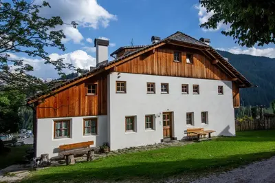 a large white building with a wooden roof at Apartments Picenin in La Villa