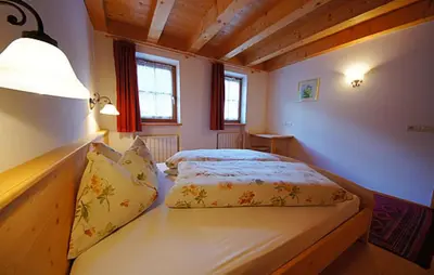 a small bedroom with a bed with a lamp on it at Apartments Picenin in La Villa