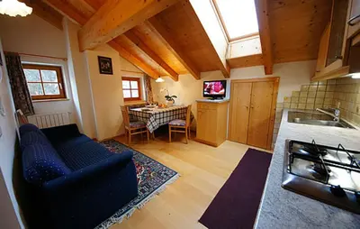 a living room with a blue couch and a table at Apartments Picenin in La Villa