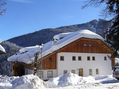 a building with snow on the roof of it at Apartments Picenin in La Villa