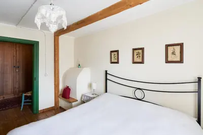 a bedroom with a white bed and a green door at Conte Moro, ospitalità in Vanoi in Canale San Bovo