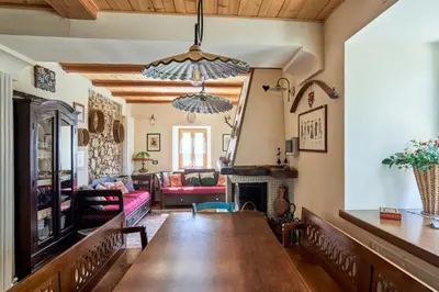 a living room with a table and a fireplace at Conte Moro, ospitalità in Vanoi in Canale San Bovo