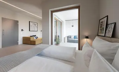 a bedroom with a white bed and a sliding glass door at La Loggia Georg in Pianizza di Sopra