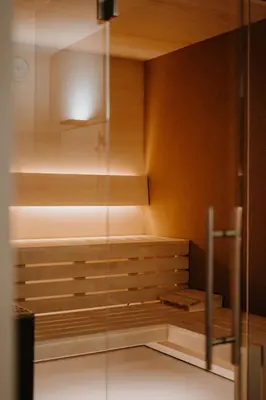 a sauna with wooden cabinets and a glass wall at La Loggia Georg in Pianizza di Sopra