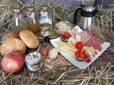 a table with a plate of food with cheese and apples at Stillehof - Ferienwohnungen auf dem Bauernhof- Südtirol in Bressanone