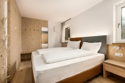 a large white bed in a room with a window at Stillehof - Ferienwohnungen auf dem Bauernhof- Südtirol in Bressanone