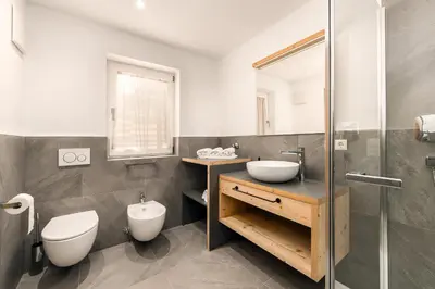 a bathroom with a toilet and a sink and a shower at Stillehof - Ferienwohnungen auf dem Bauernhof- Südtirol in Bressanone