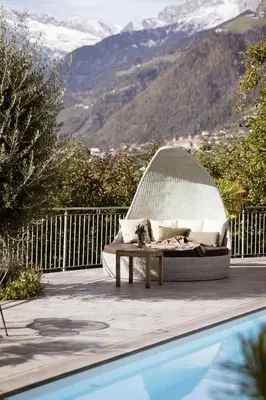 a pool with a couch and a table next to a swimming pool at Residence Walchhof in Schenna