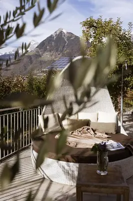 a white couch on a deck with a table at Residence Walchhof in Schenna