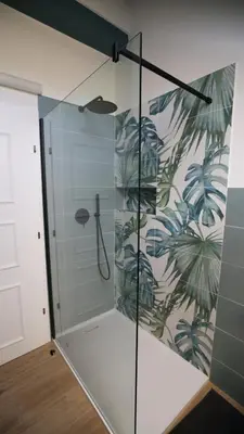 a shower stall with a glass door with a mural at Appartamento Lichtenegg a Merano in Merano