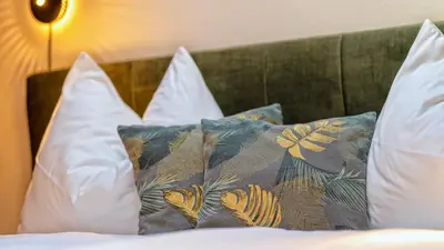 a group of pillows on a bed in a room at Appartamento Lichtenegg a Merano in Merano