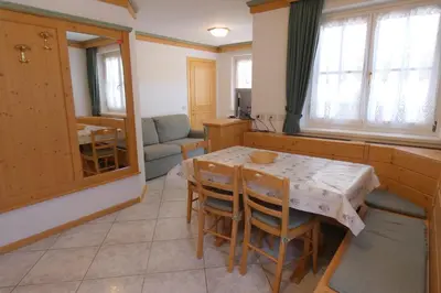 a kitchen with a table and chairs in a room at Villetta Enrosadira in Vigo di Fassa