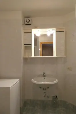 a bathroom with a sink and a mirror at Villetta Enrosadira in Vigo di Fassa