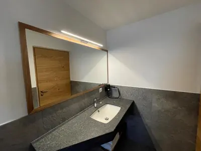 a bathroom with a sink and a mirror at MESNERHOF CHALET - Ruhe, Rückzug & Südtiroler Charme mit kostenlosem Parken in der Tiefgarage in Bressanone