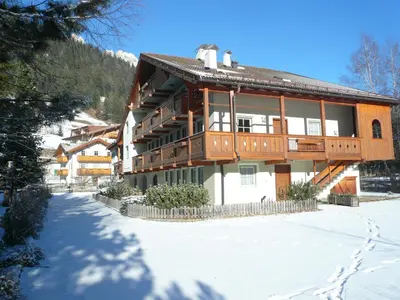 a large wooden house in the snow at Casa El Tobià in Pozza di Fassa