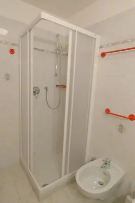 a bathroom with a shower and a toilet and a sink at Casa El Tobià in Pozza di Fassa