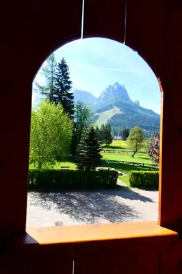 an arched window with a view of a mountain at Casa El Tobià in Pozza di Fassa