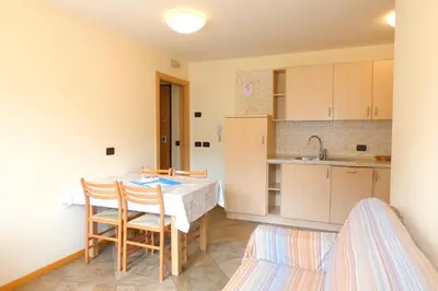 a kitchen with a table and chairs in a room at La Meisules in Pozza di Fassa